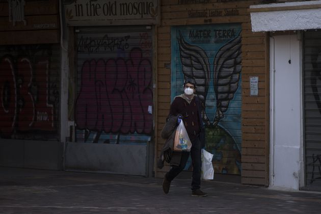 ATHENS, GREECE - DECEMBER 03: People wear protective face masks on empty streets after Greek government...