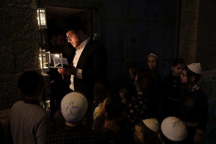 A Jewish man lights candles in observance of Hanukkah in Jerusalem, Thursday, Dec. 10, 2020.