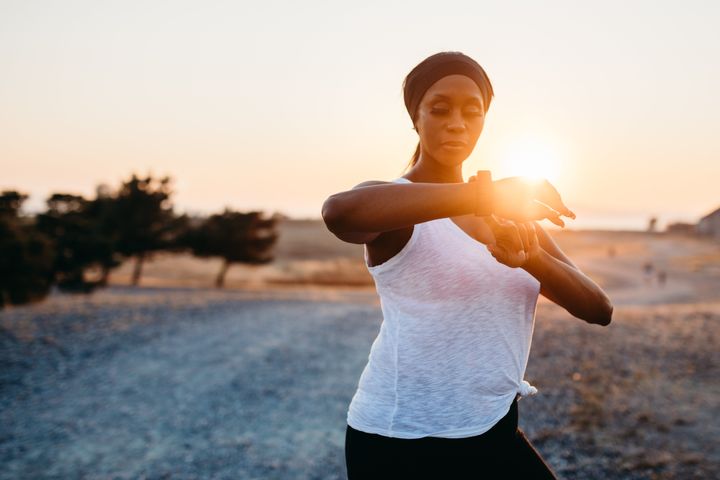 A fit and active African American woman on an evening jog in Washington state, enjoying the beauty of the outdoors and vitality she feels from a healthy lifestyle.