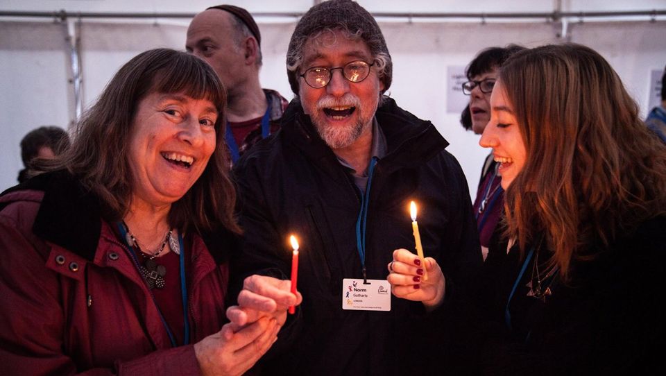 Dr Lindsay Taylor-Guthartz with her husband and one of her daughters  who is married with two daughters lighting candles for Hanukkah a few years ago