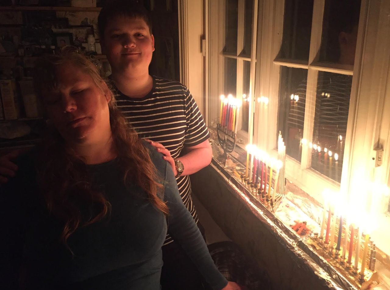 Rabbi Zvi Solomon's wife and son with Hanukkah candles on a previous year