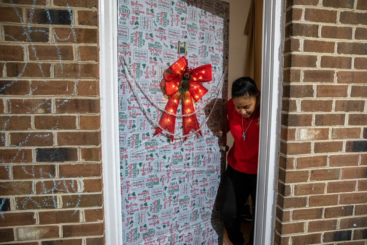 Nawaal Walker stands at her decorated door in her home in Durham, North Carolina. Walker, a single mother of seven, is facing eviction. 