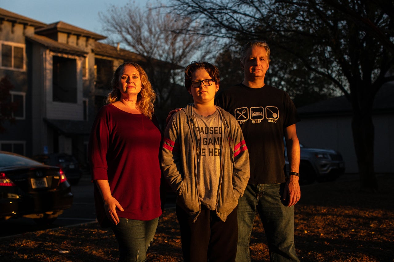Kandis, Cooper and Rob Seaver stand for a portrait at their apartment complex in Austin, Texas, on Dec. 8, 2020.