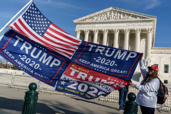 Kathy Kratt of Orlando, Fla., displays her Trump flags as she and other protesters demonstrate their support for President Donald Trump at the Supreme Court in Washington, Friday, Dec. 11, 2020. (AP Photo/J. Scott Applewhite)