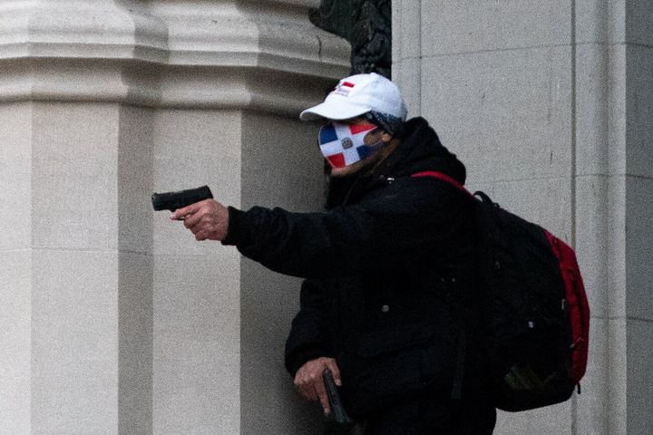 A man wearing a protective mask points his guns outside the Cathedral Church of St. John the Divine in the Manhattan borough of New York City on December 13, 2020.