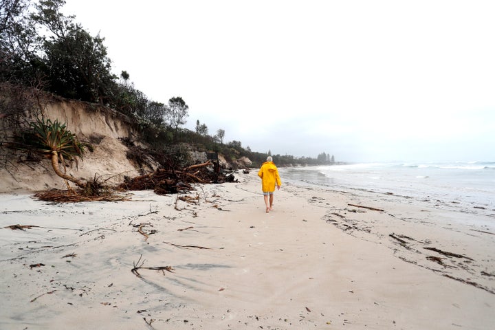 A man walks along the stretch of coastal areas seen disappeared due to erosion along the beach side, December 14, 2020 in Byron Bay, Australia. 