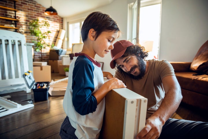 Close up of a father and son making a crib in their new home