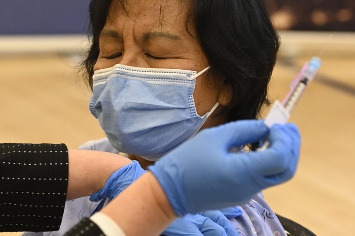 The first Pfizer-BioNTech COVID-19 vaccine in Ontario is administered to personal support worker Anita Quidangen at a hospital in Toronto on Dec. 14, 2020.