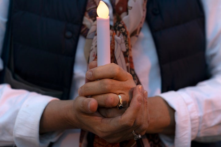 Amy Sommers, of Seattle, prays while attending the "Mourning Into Unity" vigil on Oct. 19 near the White House. Washington's Church of the Epiphany hosted a national candlelight vigil where hundreds of feet of purple fabric symbolizing mourning during COVID-19 was unfurled.