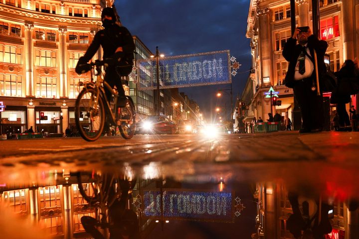 A cyclist moves cycles past the Christmas lights on Oxford Street amid the coronavirus disease (COVID-19) outbreak in London, Britain, November 19, 2020. REUTERS/Simon Dawson TPX IMAGES OF THE DAY