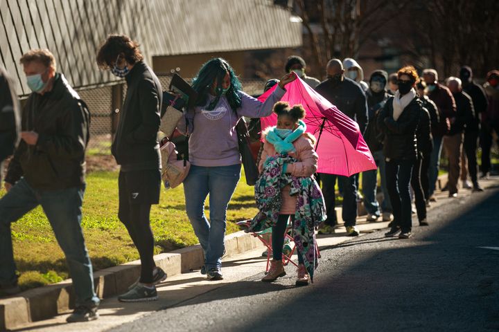 Voters wait in a long line to vote in Atlanta on the first day of in-person early voting for the U.S. Senate runoff election in Georgia on Dec. 14, 2020. 