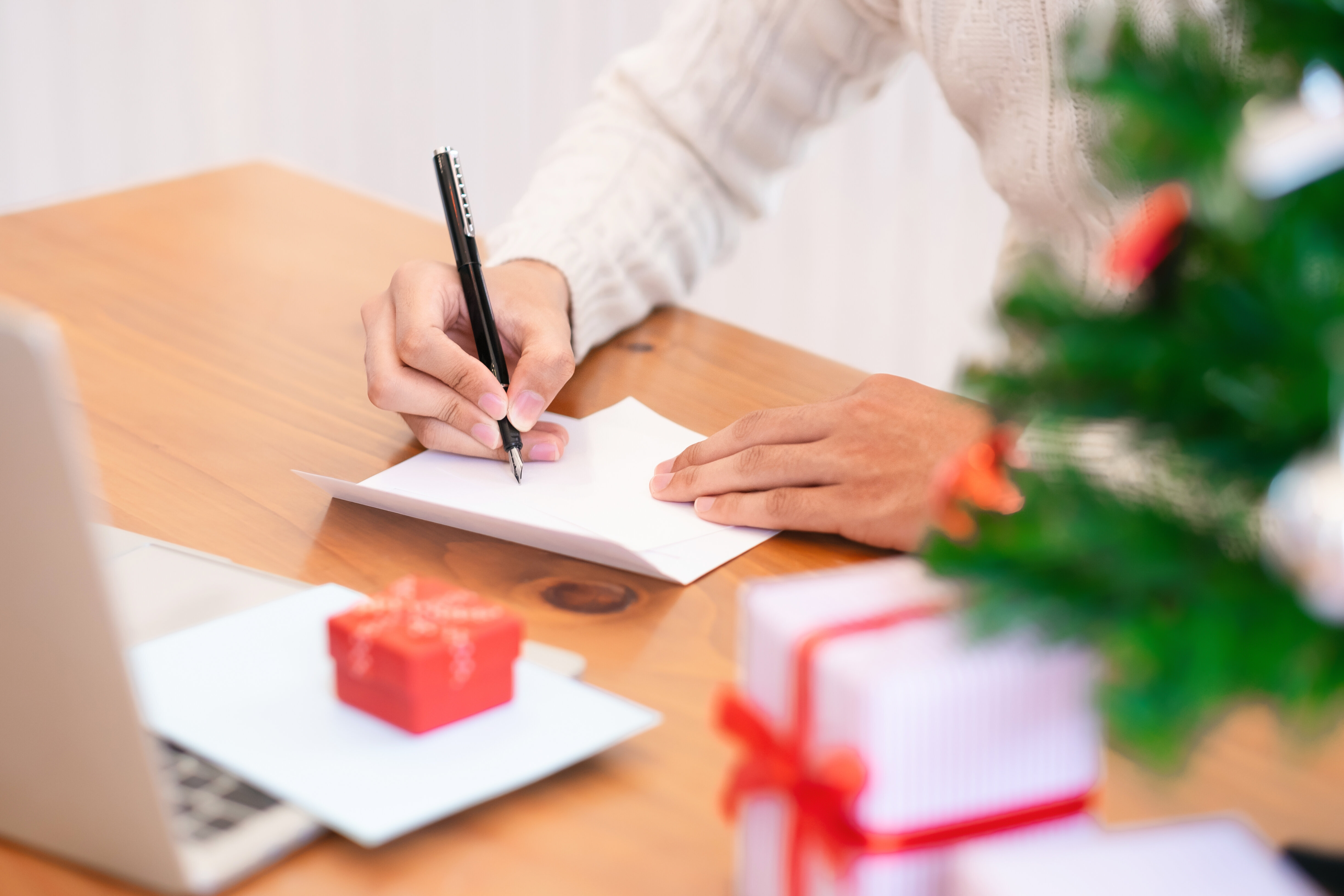 Female hand writing letter to Santa Claus over blue background with festive  Christmas decorations, confetti, fir tree branches, snowflakes, gift box.  Christmas, New Year, winter holiday concept Stock Photo by ©savanevich  308975568