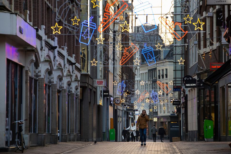 A person walks along the near-empty Kalverstraat pedestrian shopping street in the center of Amsterdam on Dec. 15. Dutch Prim