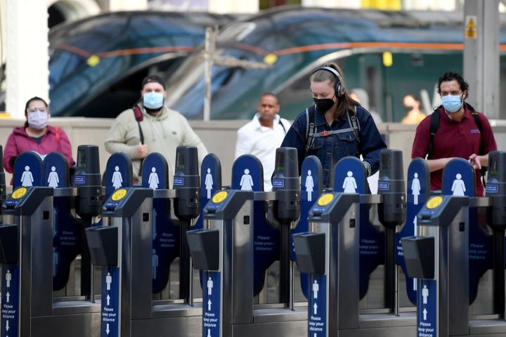 Commuters wearing face masks arrive at Paddington station 