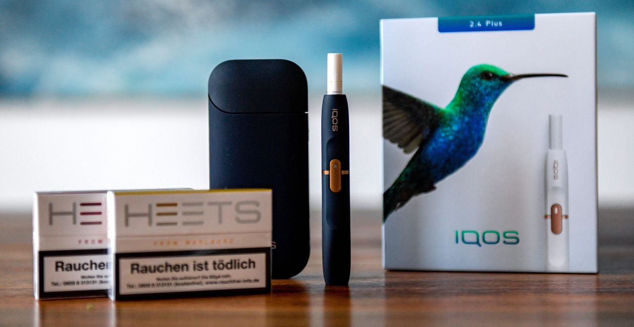 Philip Morris International's IQOS, a heated tobacco device, with a charger and "Heets" tobacco cartridges.