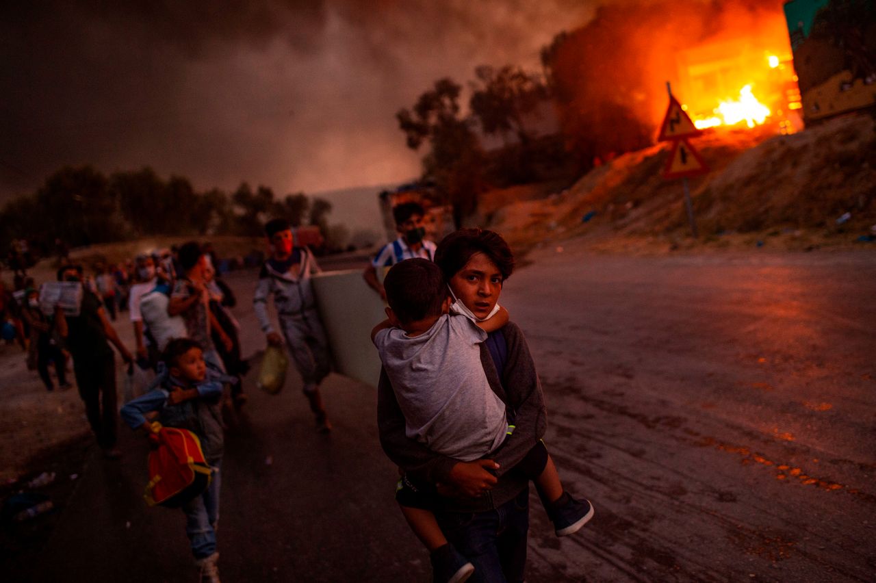 Thousands of asylum-seekers on the Greek island of Lesbos flee for their lives on Sept. 9 as a huge fire rips through the camp of Moria, the country's largest and most notorious migrant facility. More than 12,000 men, women and children ran in panic out of containers and tents and into adjoining olive groves and fields as the fire destroyed most of the overcrowded, squalid camp. The blaze started just hours after the migration ministry said 35 people at the camp had tested positive for the coronavirus.