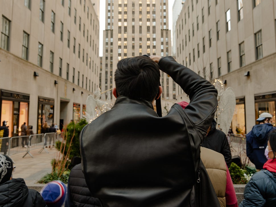 A man takes a photo of the Christmas tree at Rockefeller Center in midtown Manhattan.