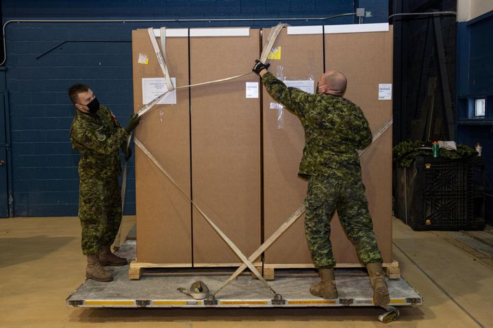 Άνδρες των Ενόπλων Δυνάμεων του Καναδά μεταφέρουν ειδικά ψυγεία συντήρησης για τα εμβόλια COVID-19. 12 Δεκεμβρίου 2020. Cpl Matthew Tower/Canadian Forces Combat Camera/Canadian Armed Forces/Handout via REUTERS. THIS IMAGE HAS BEEN SUPPLIED BY A THIRD PARTY.