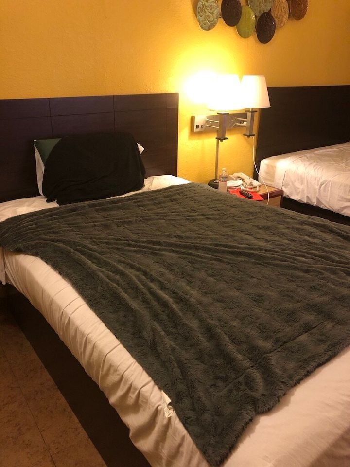 The Hotel COVIDfornia bed with the super-comfy blanket the author brought with her.