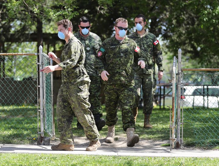 Military personnel are seen changing shifts behind the Eatonville Care Centre in Toronto on May 26, 2020. 