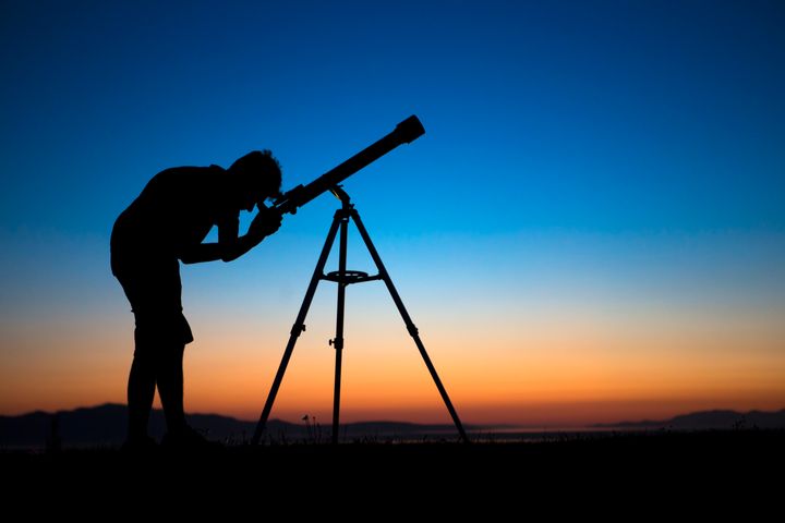 望遠鏡で天体観察をする少年のイメージ写真