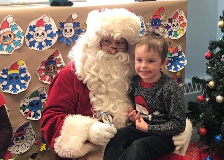 The writer's son sits with an unnamed actor portraying Santa Claus.