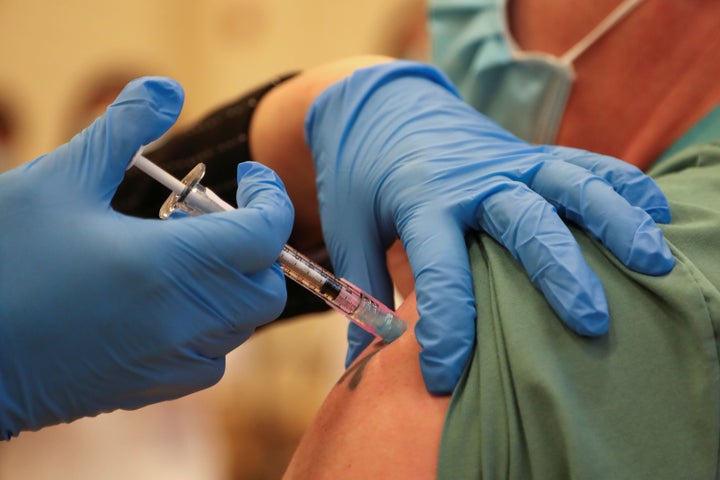 Derek Thompson, a personal support worker, is inoculated with the Pfizer/BioNTEch COVID-19 vaccine at The Michener Institute, in Toronto on Dec. 14, 2020.
