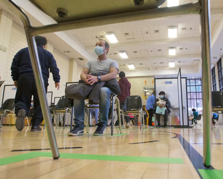 Following the administration of the vaccine, RPN Achut Kafle, who works in a long-term care home, waits the customary 15 minutes before exiting the UHN's facility on Dec. 15, 2020.