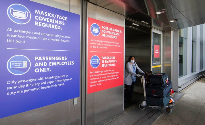 A passenger wearing a face mask leaves Terminal 1 of Pearson International Airport in Toronto, Aug. 3, 2020.