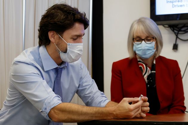 Prime Minister Justin Trudeau. with Health Minister Patty Hajdu, holds an empty COVID-19 vaccine vial...