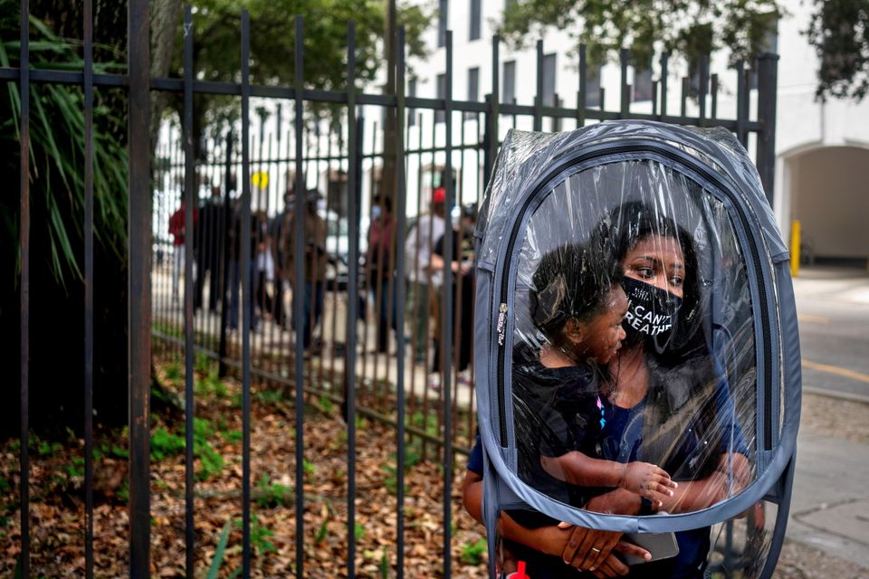 Dana Clark and her 18-month-old son, Mason, wait in line on Oct. 16 at City Hall as early voting begins for the U.S. presidential election in New Orleans.