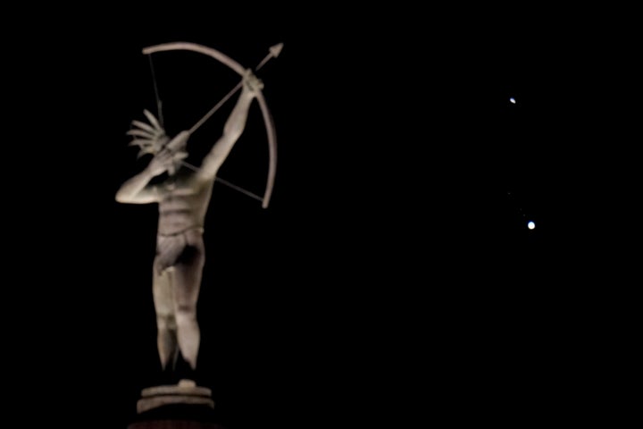 A statue of a Kansa Indian atop the Kansas Statehouse stands in the foreground as Saturn, top, and Jupiter, below, are seen Saturday, Dec. 19, 2020 in Topeka, Kansas.