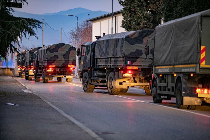 Italian military trucks drive through the streets of Bergamo, Italy, on March 18 after the army was deployed to move coffins from the town to neighboring provinces after funeral services were overwhelmed.