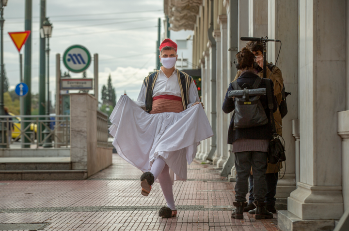 Ο Φοίβος Δεληβοριάς με φουστανέλα και μάσκα στην αρχή της Πανεπιστημίου. 