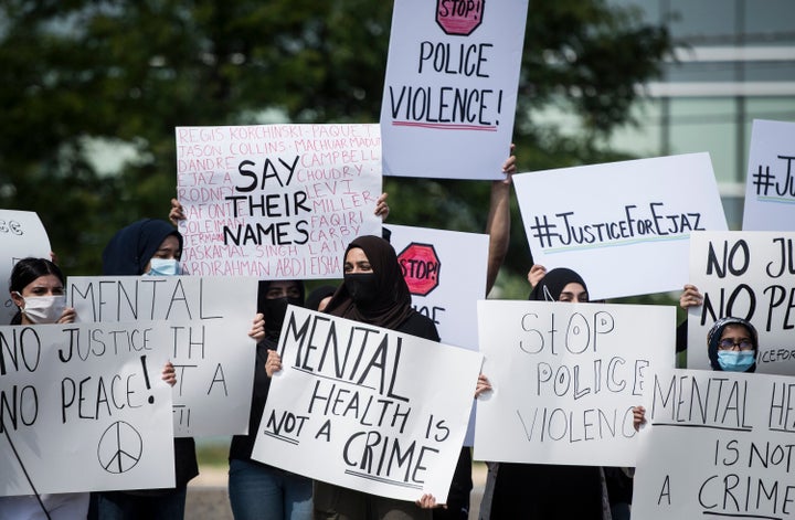 People hold signs in solidarity during a rally for justice for Ejaz Choudry, a 62-year-old man who was killed in a Peel Regional Police-involved shooting, in Mississauga, Ont. on Saturday, June 27, 2020.