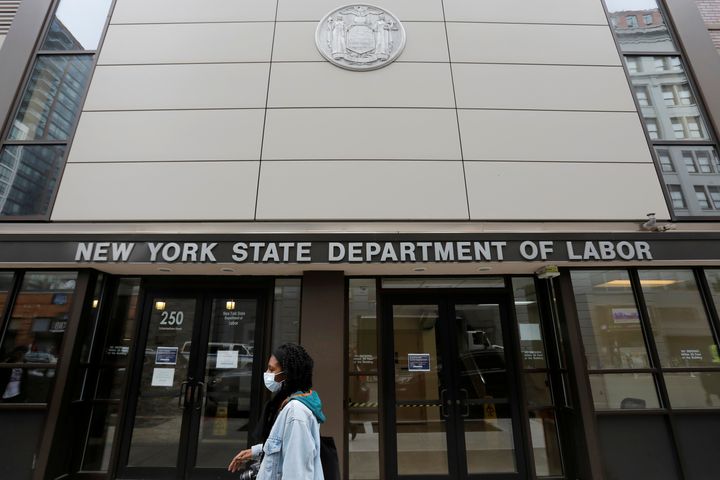 A person walks by the entrance of the New York State Department of Labor offices, which closed to the public due to the coronavirus disease, in Brooklyn, New York, March 20.