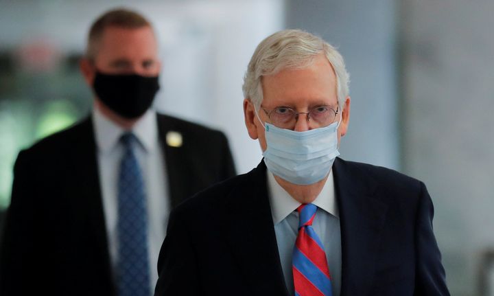 Senate Majority Leader Mitch McConnell (R-Ky.) wears a protective face mask as he walks down a hallway of the Hart Senate Off