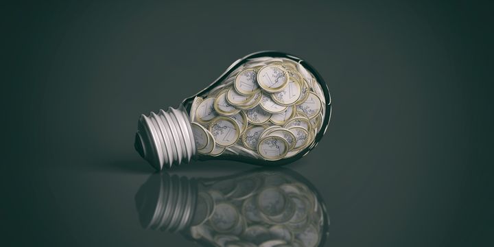 3d rendering coins inside a light bulb on black background