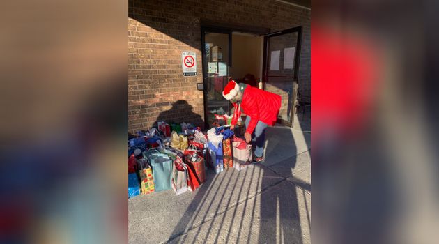 A volunteer helps with the gift drop-off at Orchard Villa in Pickering, Ont.