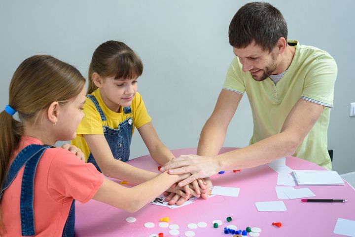 Dad and kids have fun playing a board game