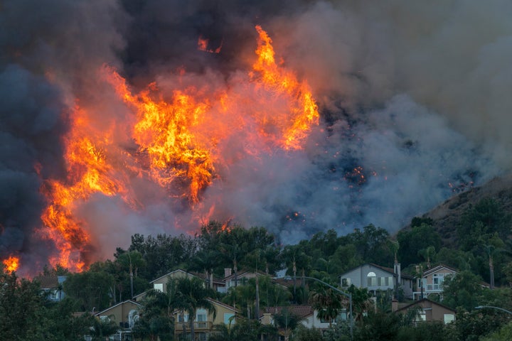 Flames rise near homes during the Blue Ridge fire on Oct. 27 in Chino Hills, California.