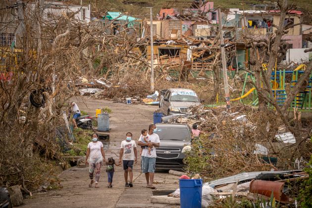 A family walks amid destruction on Nov. 22 in Providencia, Colombia, which was hit by Hurricane Iota...