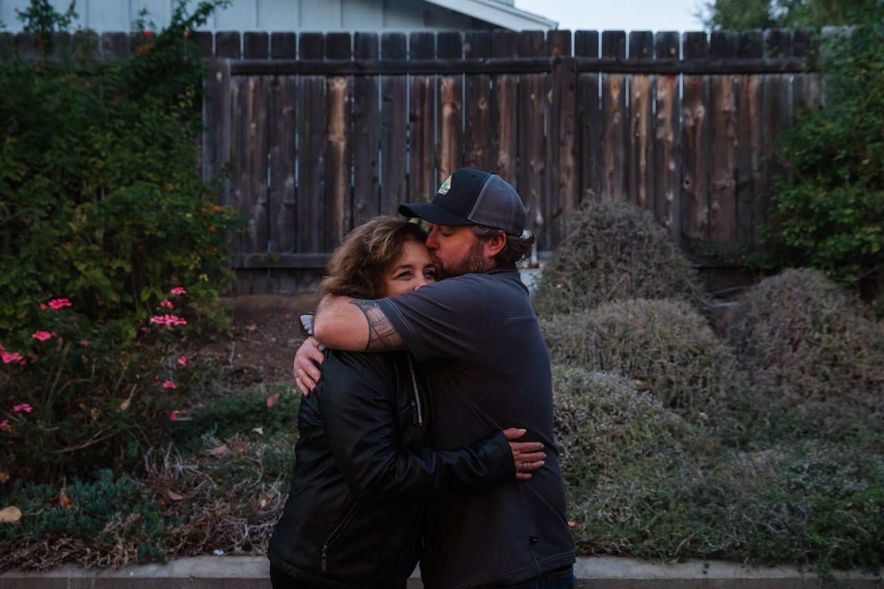 Raquel Salorio and Mike Kurtz hug in her son Joseph's backyard in San Diego.