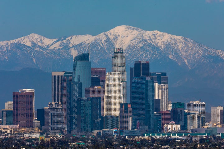 Snow is seen on the San Gabriel Mountains beyond downtown Los Angeles under a clear sky after weeks of storms and reduced traffic due to the COVID-19 stay-at-home order, on April 14, 2020. 