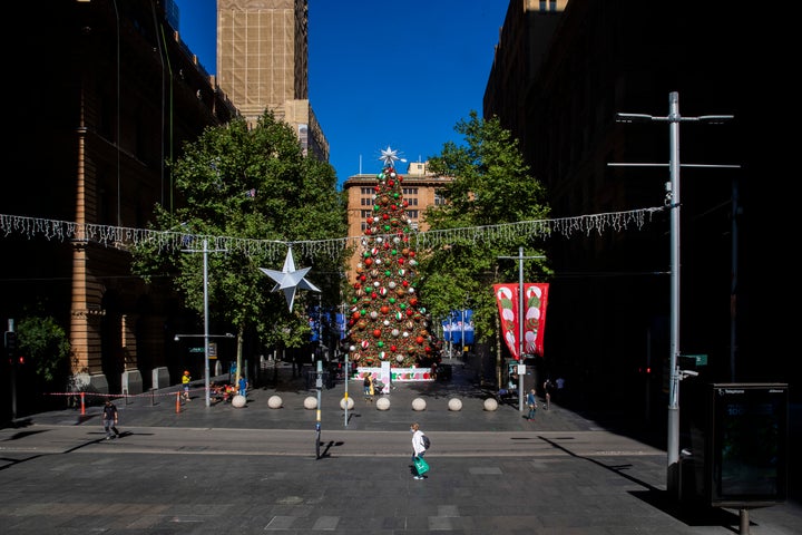 People walk past a Christmas tree in Martin Place on December 23, 2020 in Sydney, Australia. 