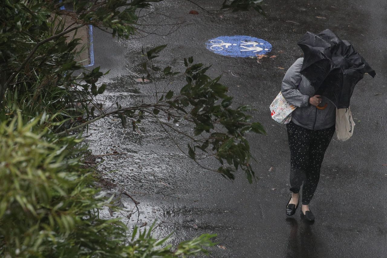 A pedestrian braves strong wind and rain in Sydney, New South Wales, February 9, 2020.