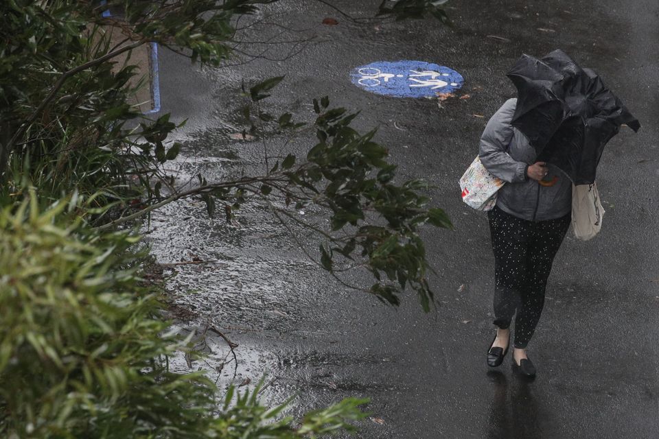 A pedestrian braves strong wind and rain in Sydney, New South Wales, February 9, 2020.