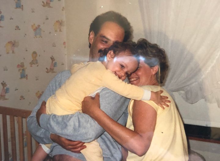 The writer as a child in the arms of her father and mother.