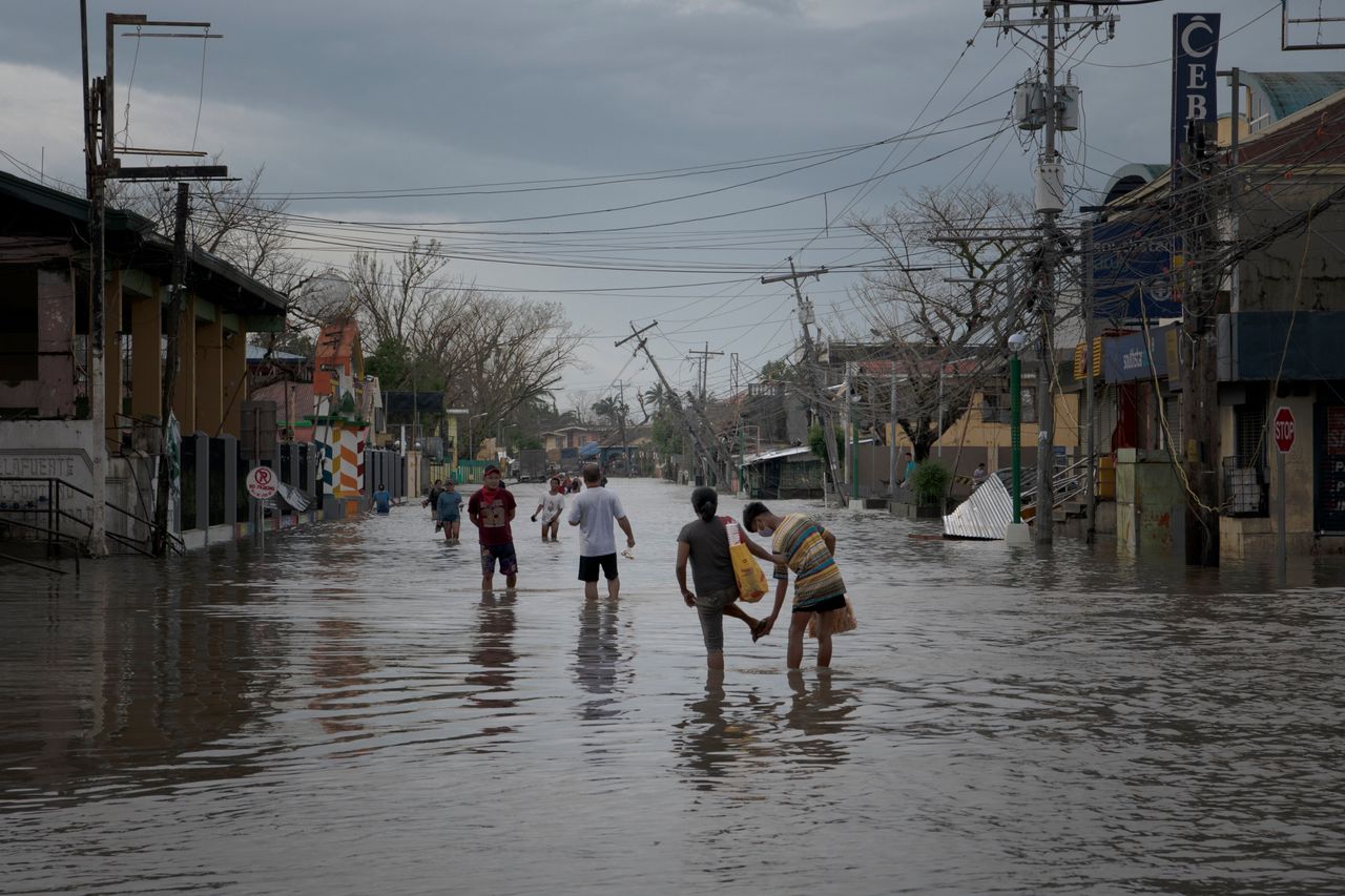  Residents wade through a flooded street in the aftermath of Super Typhoon Goni on November 2 in Nabua, Philippines. 