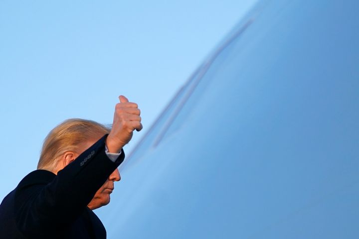 右手をあげて大統領専用機に乗り込むトランプ大統領（2020年12月23日）